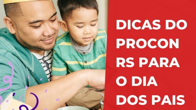 Um homem jovem de casaco azul aparece brincando com um menino em seu colo, usando roupa verde com listras amarelas.