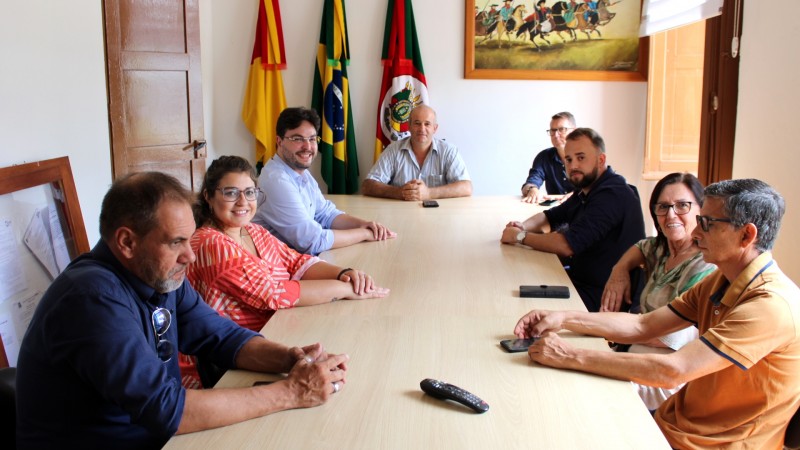Em traje formal, os representantes do Procon RS e do Procon Municipal de Piratini estão sentados ao redor de uma mesa comprida e retangular. Ao fundo, estão hasteadas as bandeiras do Brasil, Rio Grande do Sul e do município de Piratini.

Autoria da descrição da foto: Wagner Meirelles Ascom SJCDH