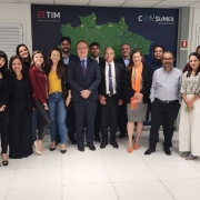 Em traje formal, os conselheiros da operadora TIM estão em pé e posam sorrindo para a foto.