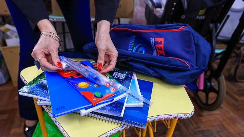 Senhora com alguns materias escolares nas mãos